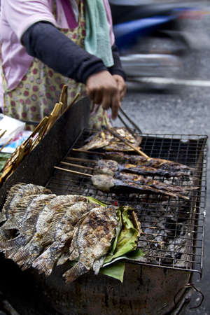 grilled salty fishs tilapia,catfish  in wheelbarrel on street of Bangkok  ,Thailandの写真素材