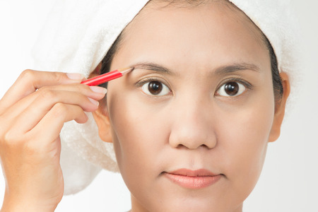 Portrait of young woman using eyebrows pencilの写真素材
