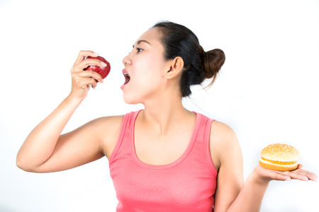 asian woman with apple and hamburgerの写真素材