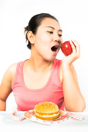 asian woman with apple and hamburgerの写真素材
