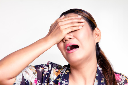 Asian woman covering her eyes and yellの写真素材