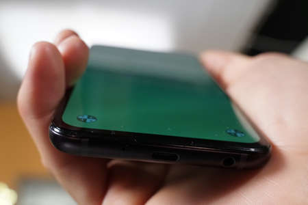 closeup of hand holding mobile phone with greenscreen to be mocapの写真素材