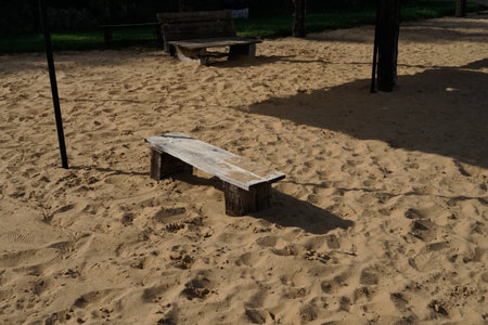 Wooden bench on the sand in a park in the summer.