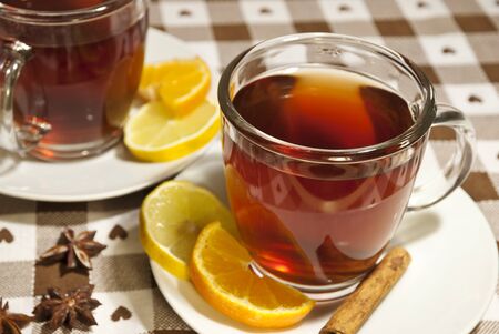 Tea cups at the table with slice of orange and lemonの写真素材