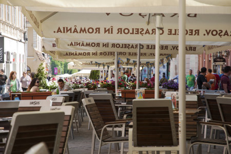 BRASOV, ROMANIA - MAY 3: People having coffee in a bar on the street of Brasov, Romania on May 3, 2013.のeditorial素材