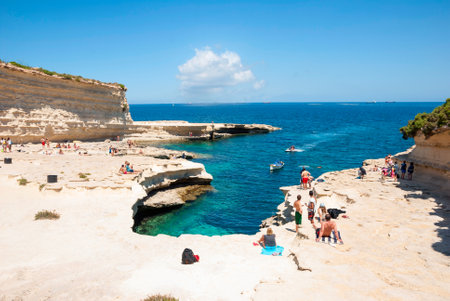 Marsaskala, Malta - May 31  People sunbathing and swimming on the rocks of Marsaskala beach, Matla at May 31, 2014のeditorial素材