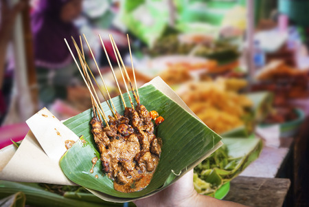 Indonesian chicken satay served in leaf on the food marketの写真素材