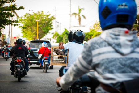 YOGYAKARTA, INDONESIA - SEPTEMBER 15: Driving in a local road between motorbikes and cars in Yogyakarta, Indonesia on Sept. 15, 2014.のeditorial素材