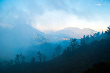 View to silhouette of forest over the clouds in the mountains of Kawah Ijen, Java, Indonesiaの写真素材
