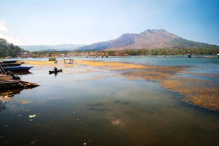 Fisherman at Danar batur lake in volcanic caldera in Bali, Indonesiaの写真素材
