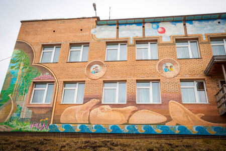 BARENTSBURG, NORWAY - JUNE 21: Colorful painitings with norwegian and russian motifs pained on school facade on Barentsburg school on June 21, 2015のeditorial素材