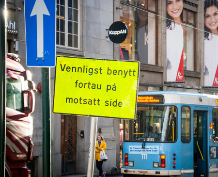 OSLO, NORWAY - JANUARY 29: Work on road in Oslo donwtown with sign saying "Please use the sidewalk on opposite side" on Jan 29, 2015のeditorial素材