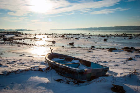 Boat frozen in fjord in winter sunshine, Norwayの写真素材