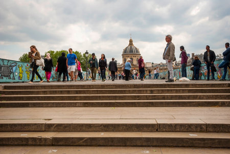 PARIS, FRANCE - JUNE 9: People passing Pont des Arts bridge in Paris where padlocks were removed from the fence on June 9, 2015のeditorial素材