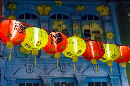 View on bright illuminated garland against of beautifully painted building facade in China town, Singaporeの写真素材