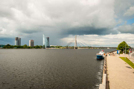 Overcast clouds over Daugava river with modern bridge, Riga, Latviaの写真素材