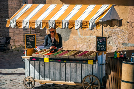 TALLINN, ESTONIA - AUGUST 15: Woman selling local candies on street market stand in Tallinn oldtown on sunny day. August 2015のeditorial素材