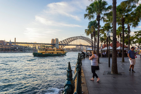 SYDNEY, AUSTRALIA - APRIL 21: View on Sydney harbour bridge from embankment in the evening and people passing by. April 2016.のeditorial素材