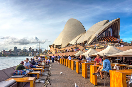 SYDNEY, AUSTRALIA - APRIL 19: People sitting at the Opera bar next to Sydney Opera house. April 2016.のeditorial素材