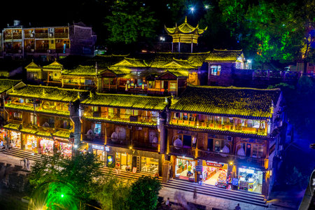 FENGHUANG CHINA - JUNE 14: Illuminated traditional Chinese architecture buildings in city's downtown by the river bank at night. June 2016のeditorial素材