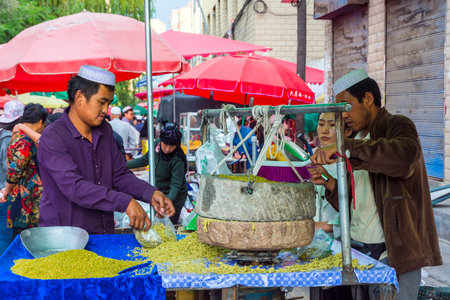 XINING CHINA - JUNE 22: Uyghurs using big stone grinder to prepare traditional food for sale at the...