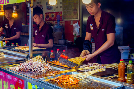 GUILIN CHINA - JUNE 11: People preparing sea food skewers at food corner in Guilin China. June 2016のeditorial素材