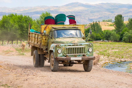 Old loaded soviet truck driving on local road in Kazakh steppeの写真素材