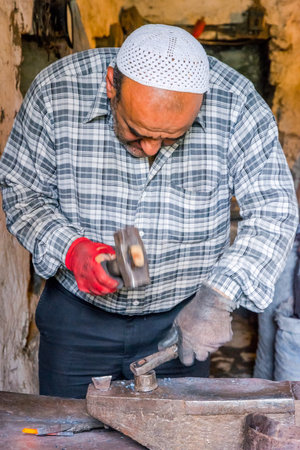 LAHICH, AZERBAIJAN - OCTOBER 1: Senior blacksmith making nails with hammer and pliers in Lahich, famous of smith tradition. October 2016のeditorial素材