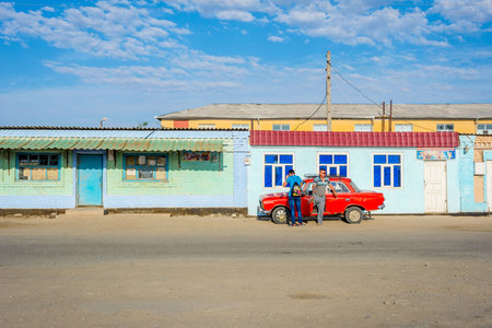 MUYNAK, UZBEKISTAN - SEPTEMBER 10: Guy speaking with the driver of old red colored car in Muynak. September 2016のeditorial素材