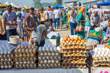 MARGILAN, UZBEKISTAN - AUGUST 21: Eggs for sale and a crowd of people visiting Kumtepa bazaar. Market is one of the biggest in the area running once a week. August 2016のeditorial素材