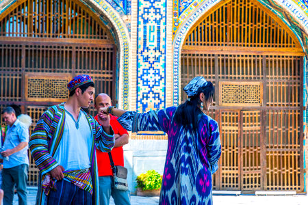 SAMARKAND, UZBEKISTAN - AUGUST 28: Broom kissing bride's hand at traditional Uzbek wedding in Samarkand Registan. August 2016のeditorial素材