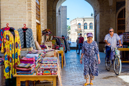 BUKHARA, UZBEKISTAN - SEPTEMBER 4: Street bazaar with souvenirs and traditional uzbek clothes in Bukhara downtown. September 2016のeditorial素材