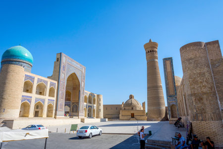 BUKHARA, UZBEKISTAN - SEPTEMBER 3: Kalyan minaret and the mosque and few gift shops on a sunny day....