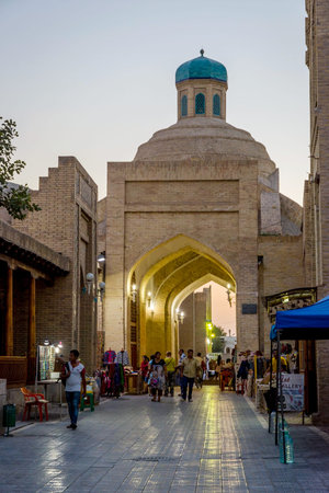BUKHARA, UZBEKISTAN - SEPTEMBER 5: People walking on Bukhara old street in early evening. September 2016のeditorial素材