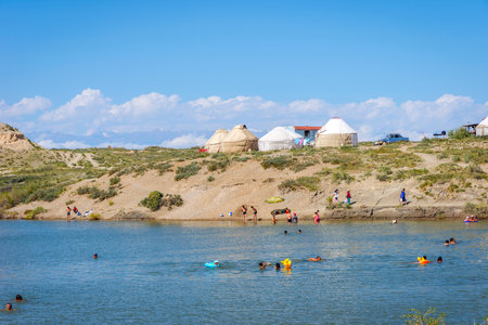 KYZYL TOO, KYRGYZSTAN - AUGUST 8: People swimming and enjoying the sunny day at Kyzyl Too salt lake. August 2016のeditorial素材