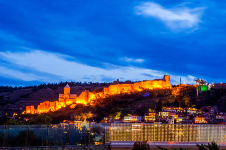 Illuminated Tbilisi castle at night with the old town, Georgia