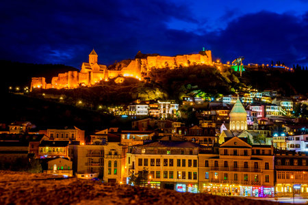 Illuminated Tbilisi castle at night with the old town, Georgia