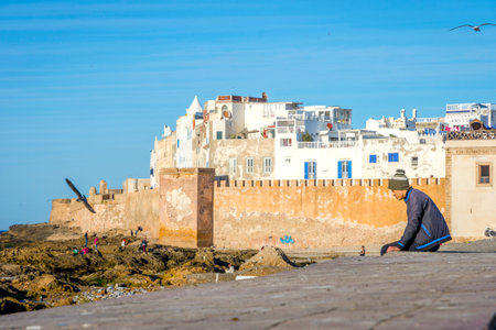 ESSAOUIRA, MOROCCO - DECEMBER 13: Guy sitting on the old city wall in Essaouira. December 2016のeditorial素材