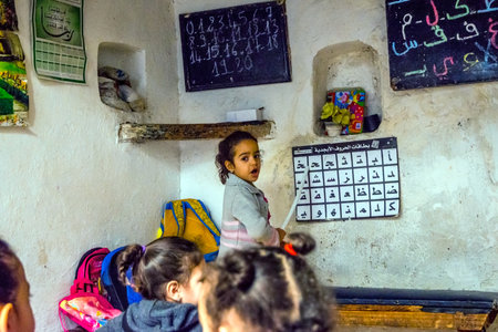 FEZ, MOROCCO - DECEMBER 10: School girl standing in front of the class and pointing to arabic letters alphabet in local school in Fez. December 2016のeditorial素材