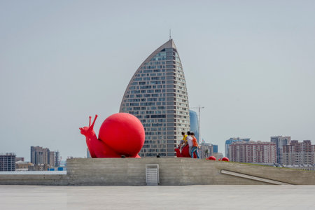 BAKU, AZERBAIJAN - MAY 27: Kids climbing on red snail at Heydar Aliyev center. Baku, May 2017のeditorial素材