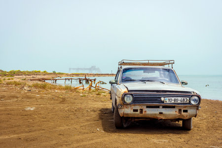 SHURAABAD, AZERBAIJAN - MAY 5: Old soviet Volga car and abandoned oil rig on the shore of Caspian sea, Azerbaijan. May 2017のeditorial素材