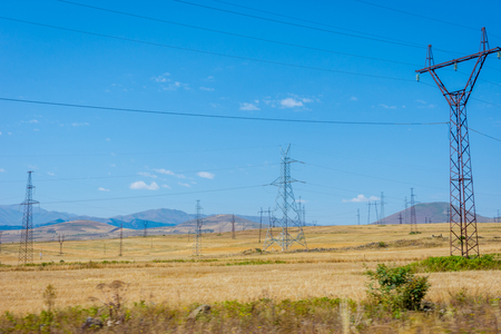 Electric wires and installation over the dry summer fields and meadows, Armeniaの写真素材