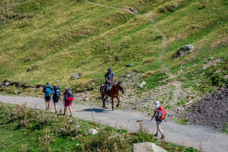 Ushguli, Georgia - September 6, 2017: Man galpping with horse on the road in Ushguli village, Svanetiのeditorial素材
