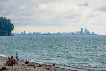 Batumi, Georgia - August 27, 2017: People on the beach against Batumi skyline at the Black sea.のeditorial素材