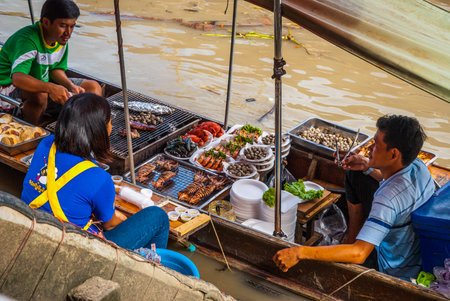 Amphawa, Thailand - Sep 13, 2015: Floating food market at Amphawa where food is cooked and prepared on the boats and serve to the people on the river canal bankのeditorial素材