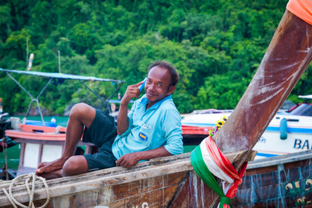 Krabi, Thailand - Oct 2, 2015: Man lying on the boat and speaking on the phone, Krabi beachのeditorial素材