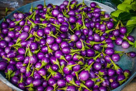 Small thai purple aubergines in the basket at local market, Thailandの写真素材