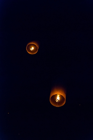 Light up lanterns flying to the sky at night during Loy Krathong festival in Chiang Mai, Thailandの写真素材