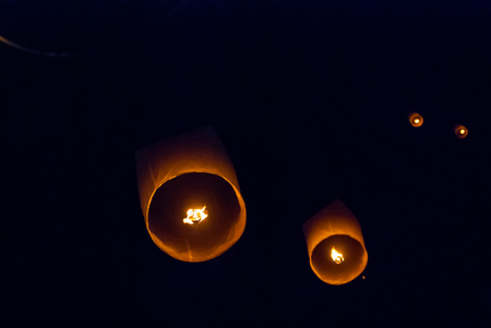 Light up lanterns flying to the sky at night during Loy Krathong festival in Chiang Mai, Thailandの写真素材