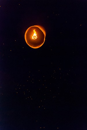 Light up lanterns flying to the sky at night during Loy Krathong festival in Chiang Mai, Thailandの写真素材